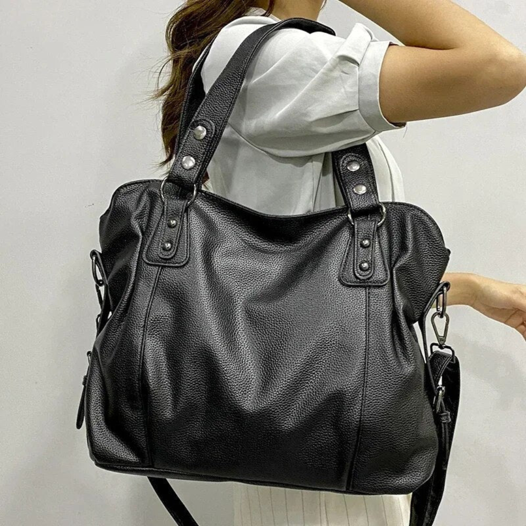 Luxurious women's black leather shoulder bag with elegant gold hardware. Stylish, sophisticated daily accessory.