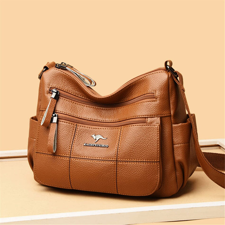 Front view of a chic women's luxury leather crossbody bag with refined gold hardware.