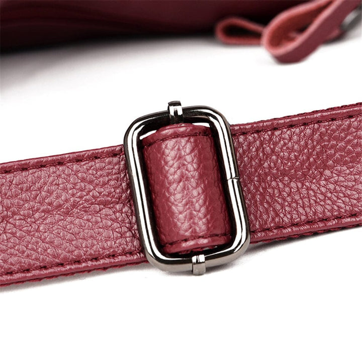 Sleek women's luxury leather handbag with unique texture and secure zip closure.