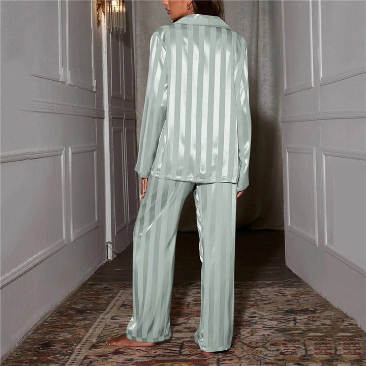 Woman enjoying a morning coffee in a luxurious silk-feel pyjama set. Comfortable relaxation wear.