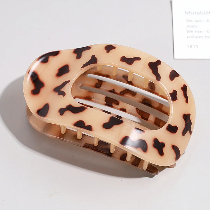Fashionable matte hair claw, an oval flat clip for women's beauty routines.