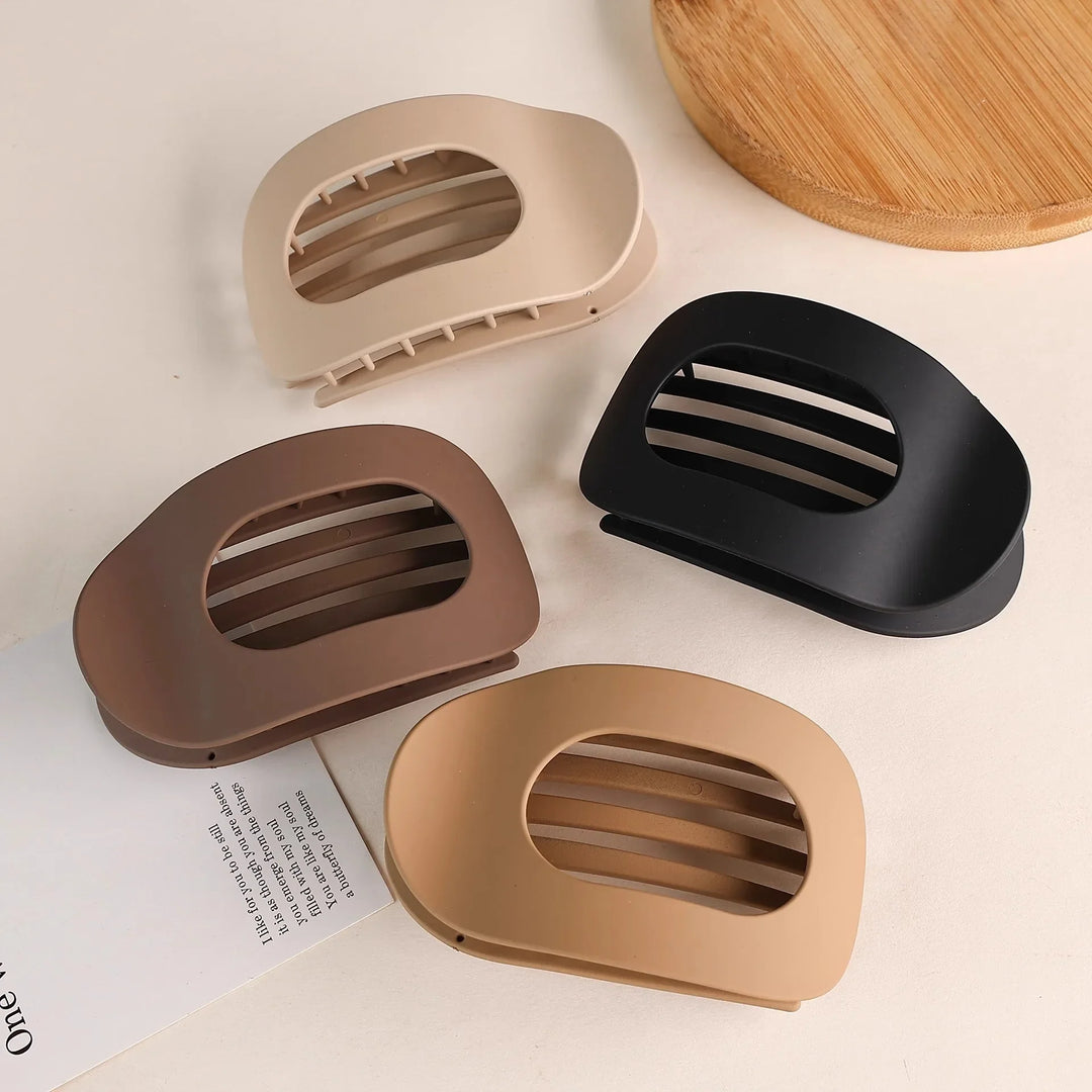 Minimalist hair bun clip, matte oval duckbill design for a clean, secure hold.