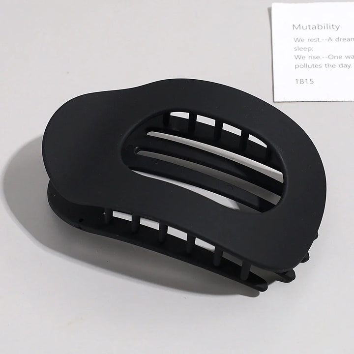 Flat oval matte claw clip, durable hair accessory for secure hold on thick hair.