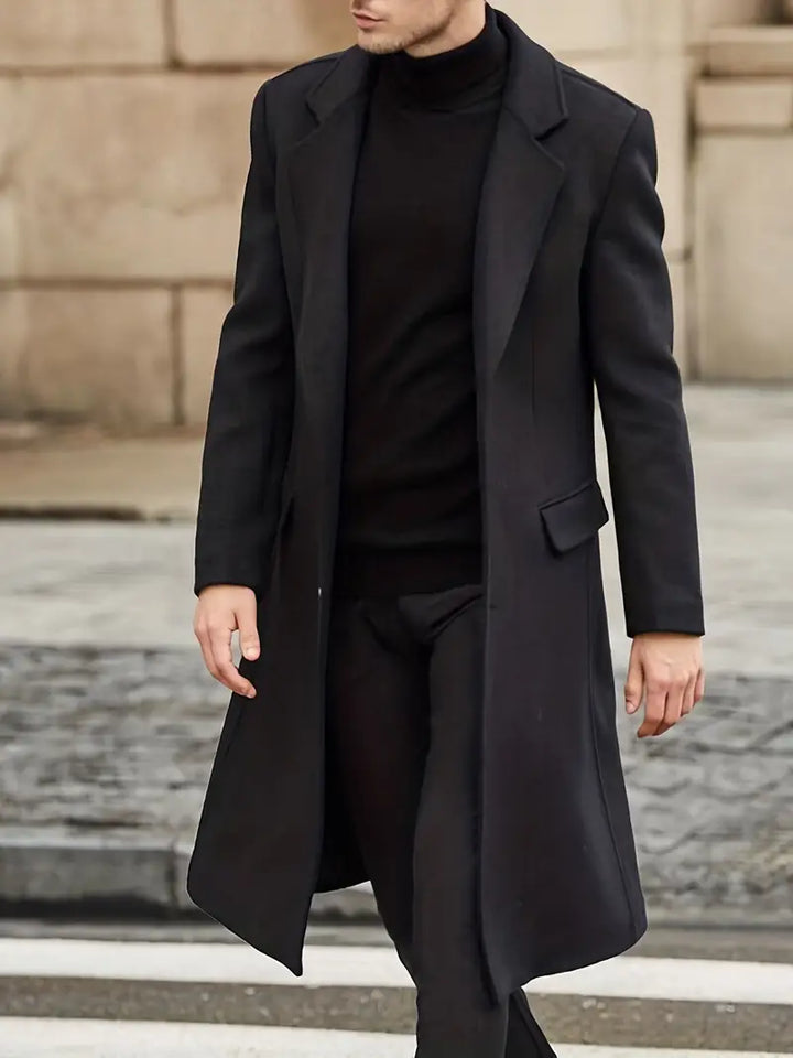 Men's black slim fit trench coat with notched lapel. Elegant long outerwear, perfect for business casual winter style.