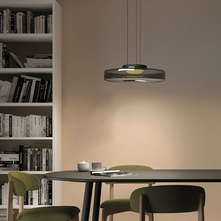 "Modern glass pendant lamp in Bauhaus design, smoke grey shade, adjustable cable, warm LED glow, ideal for home interiors."