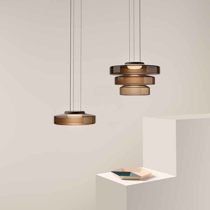 "Modern glass pendant lamp in Bauhaus design, smoke grey shade, adjustable cable, warm LED glow, ideal for home interiors."
