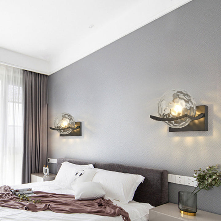 Amber glass LED wall lamp installed in a living room setting.