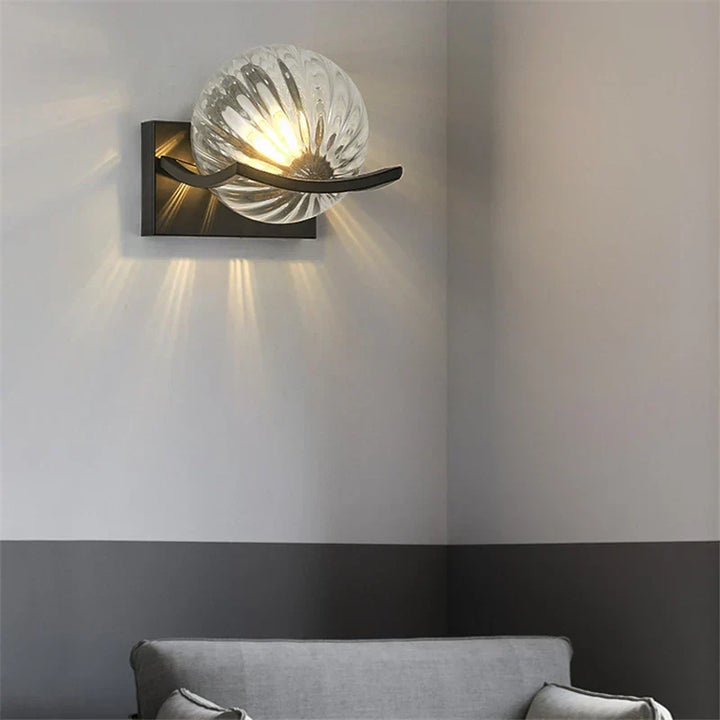 Clear glass LED wall lamp installed in a hallway.
