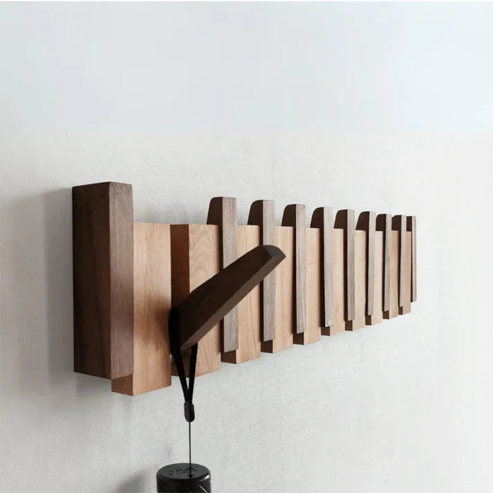 Modern wooden piano key coat rack with multiple hooks. Unique wall decor for entryway organization & style.