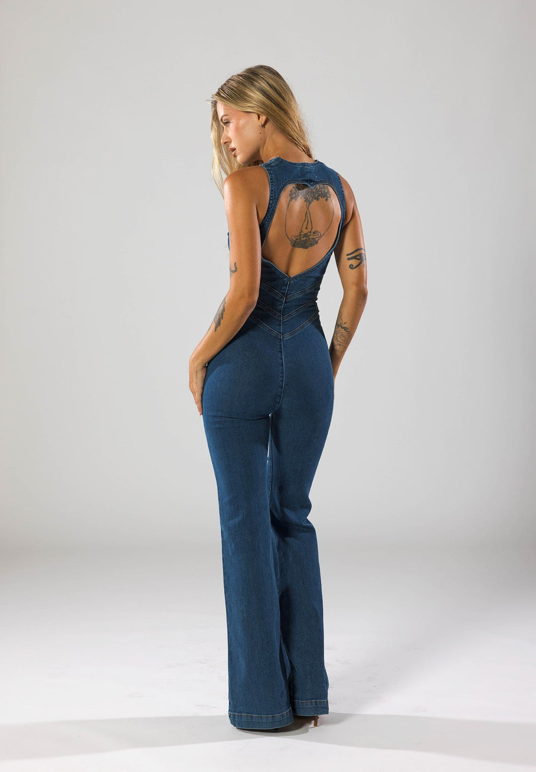 Woman wearing a chic navy blue heart-shaped plunge jumpsuit. Ideal for a stylish evening party outfit.
