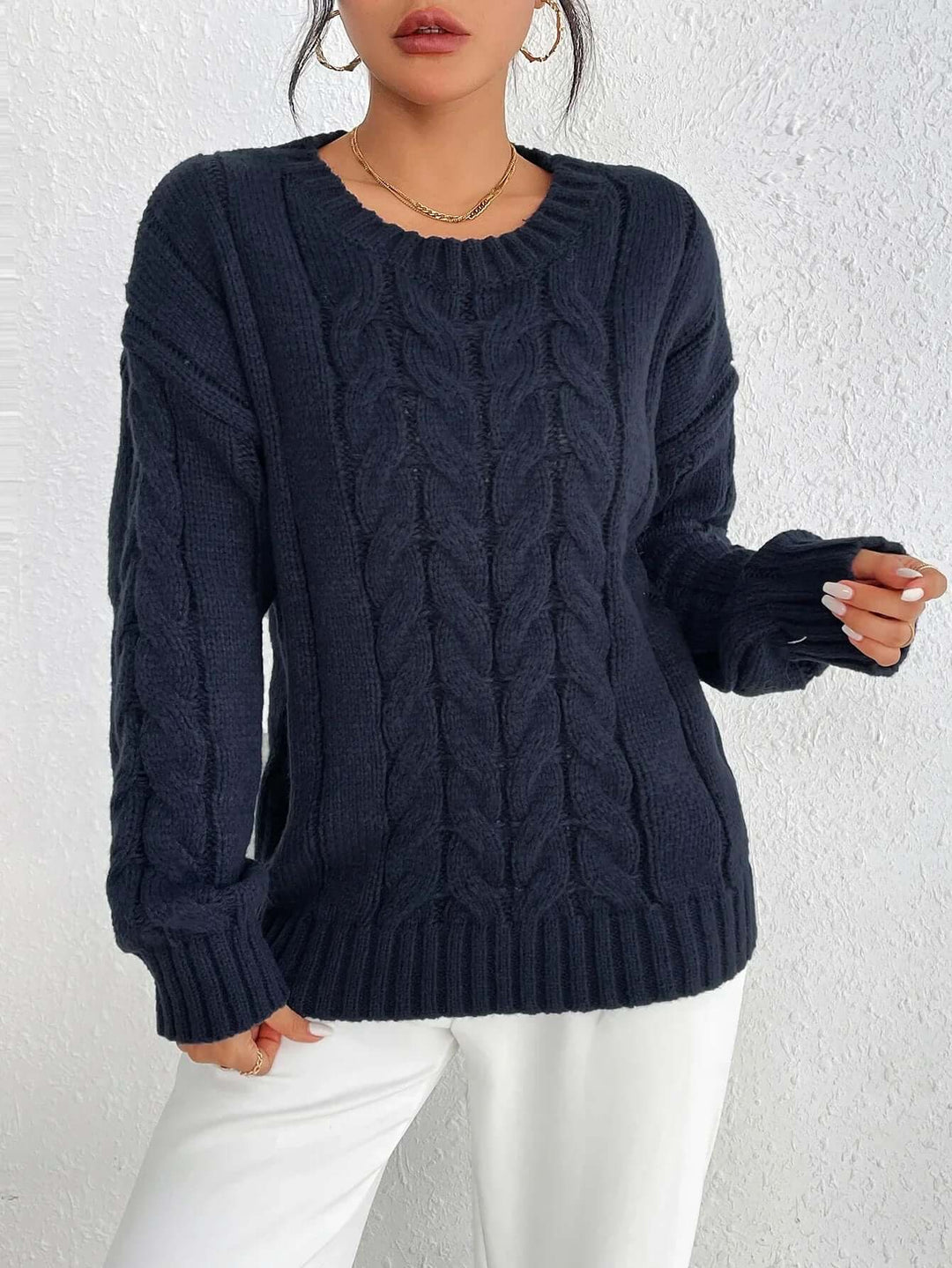 Women's navy blue twisted knit jumper. Cozy, loose fit knitted sweater for comfortable and elegant winter fashion.