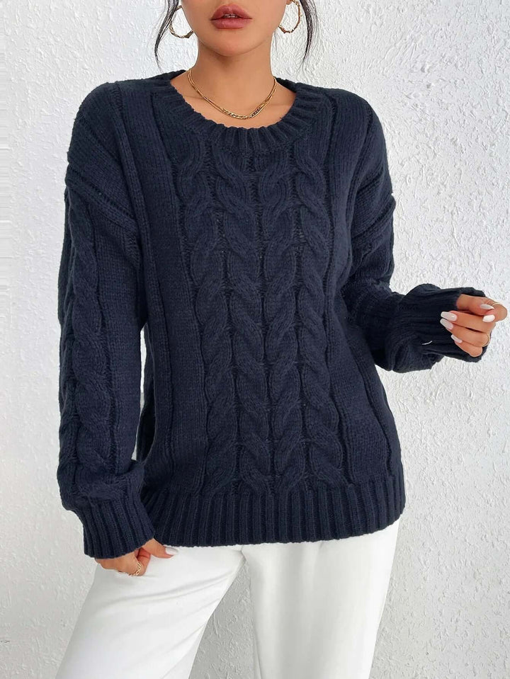 Women's navy blue twisted knit jumper. Cozy, loose fit knitted sweater for comfortable and elegant winter fashion.