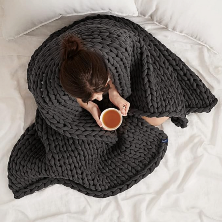 "Organic cotton weighted blanket in grey, offering cozy warmth and therapeutic pressure for all seasons. Available in multipl