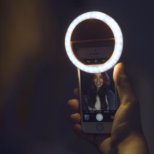 Portable LED ring light for phones, providing soft illumination for vlogging and live streaming.