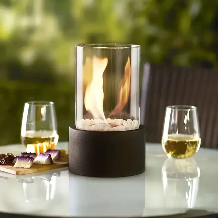 Trendy borosilicate glass & steel tabletop fire pit, a portable flame lantern for cozy indoor/outdoor decor.