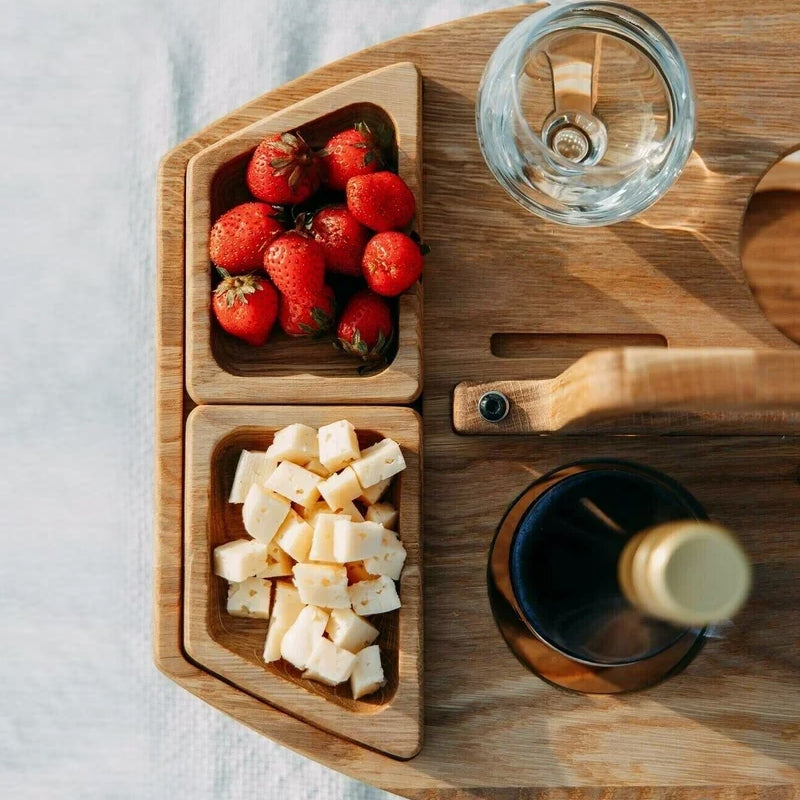 Compact foldable wooden picnic table with snack & drink slots, an essential portable outdoor serving solution.