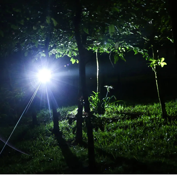 Bright beam from a waterproof LED headlamp illuminating a dark forest trail for night hiking.