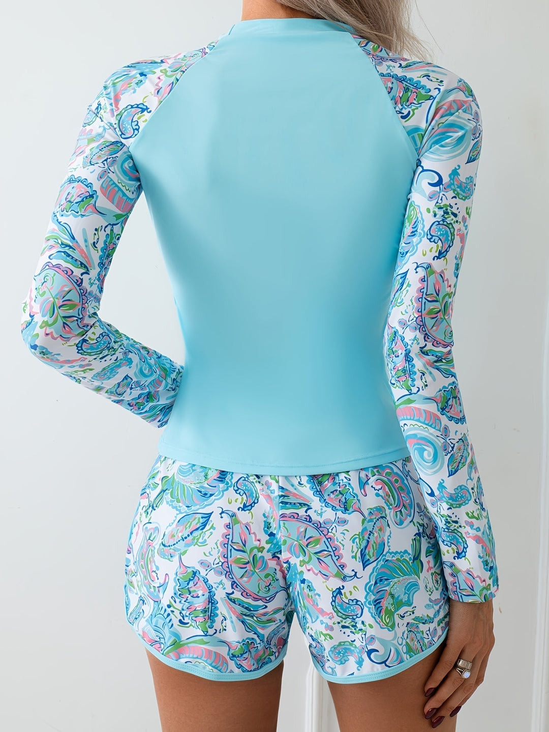 Flattering sky blue active women's swim set with long sleeves & shorts, ideal for sun protection at the beach or pool.