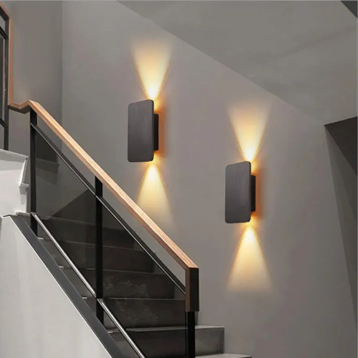"Sleek indoor LED wall lamp with a modern rectangular design, featuring smooth finishes and warm illumination for elegant dec