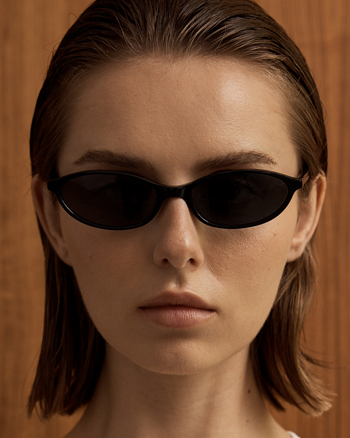 Stylish brown oval sunglasses for women, minimalist retro 90s fashion accessory.