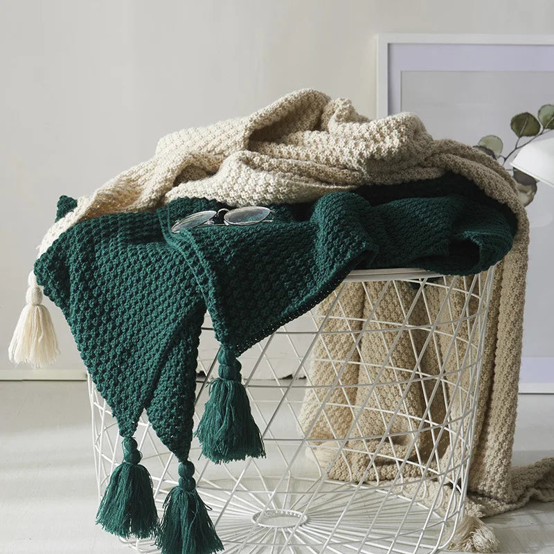 Soft knitted wool blanket with decorative tassels, perfect cozy throw for living room or bedroom comfort.