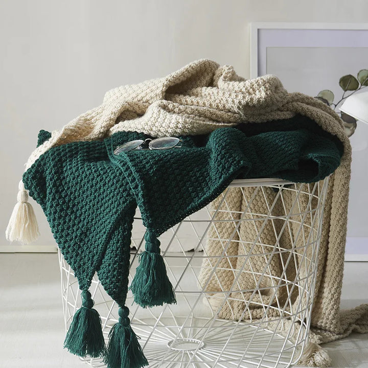 Soft knitted wool blanket with decorative tassels, perfect cozy throw for living room or bedroom comfort.