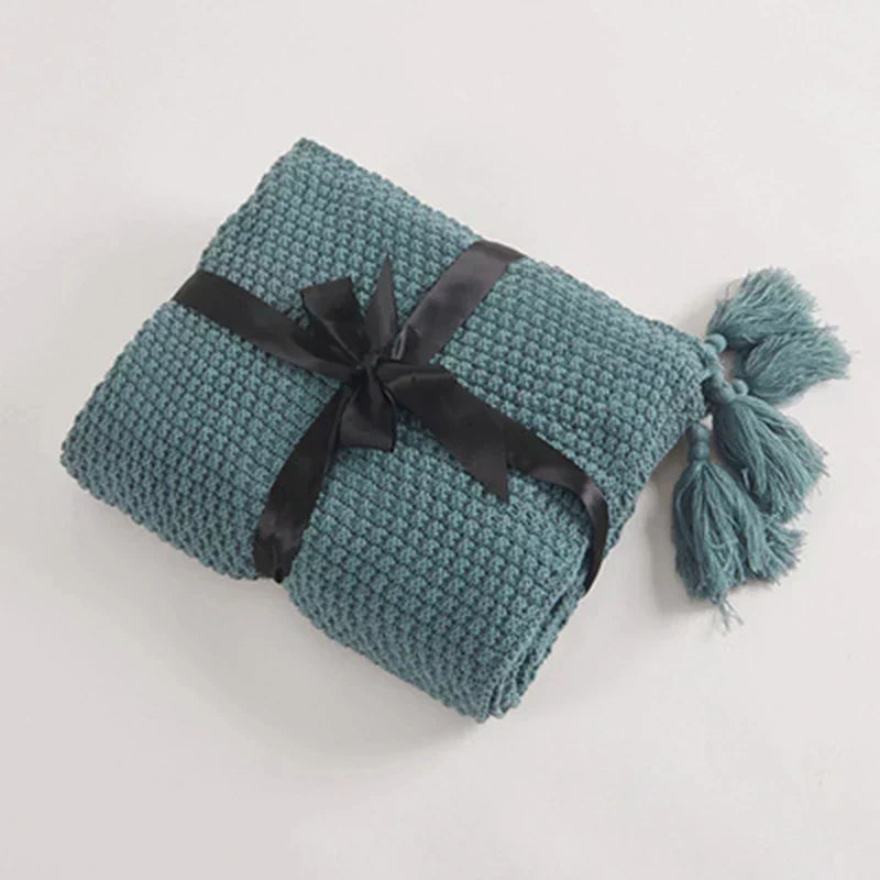 Inviting knitted wool blanket with tassels, offering supreme comfort and style as a decorative living room throw.
