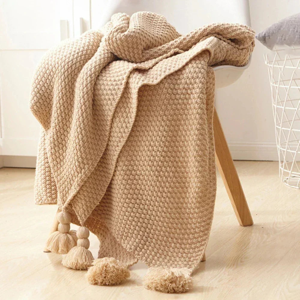 Cozy knitted wool throw blanket, perfect for adding warmth and a decorative touch with its chic tassels.