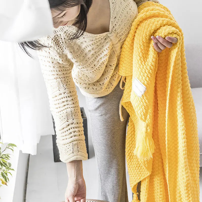 Beautiful knitted wool blanket with tassels, a warm, soft, and decorative throw ideal for a cozy home ambiance.