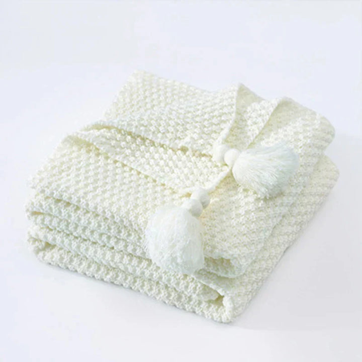 Warm knitted wool blanket, a soft and comfortable throw with delicate tassels, enhancing any home's decor.