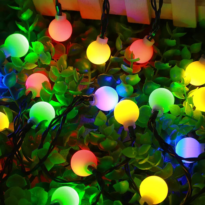 Warm glow of solar festoon string lights decorating a garden patio for evening ambiance & decor.