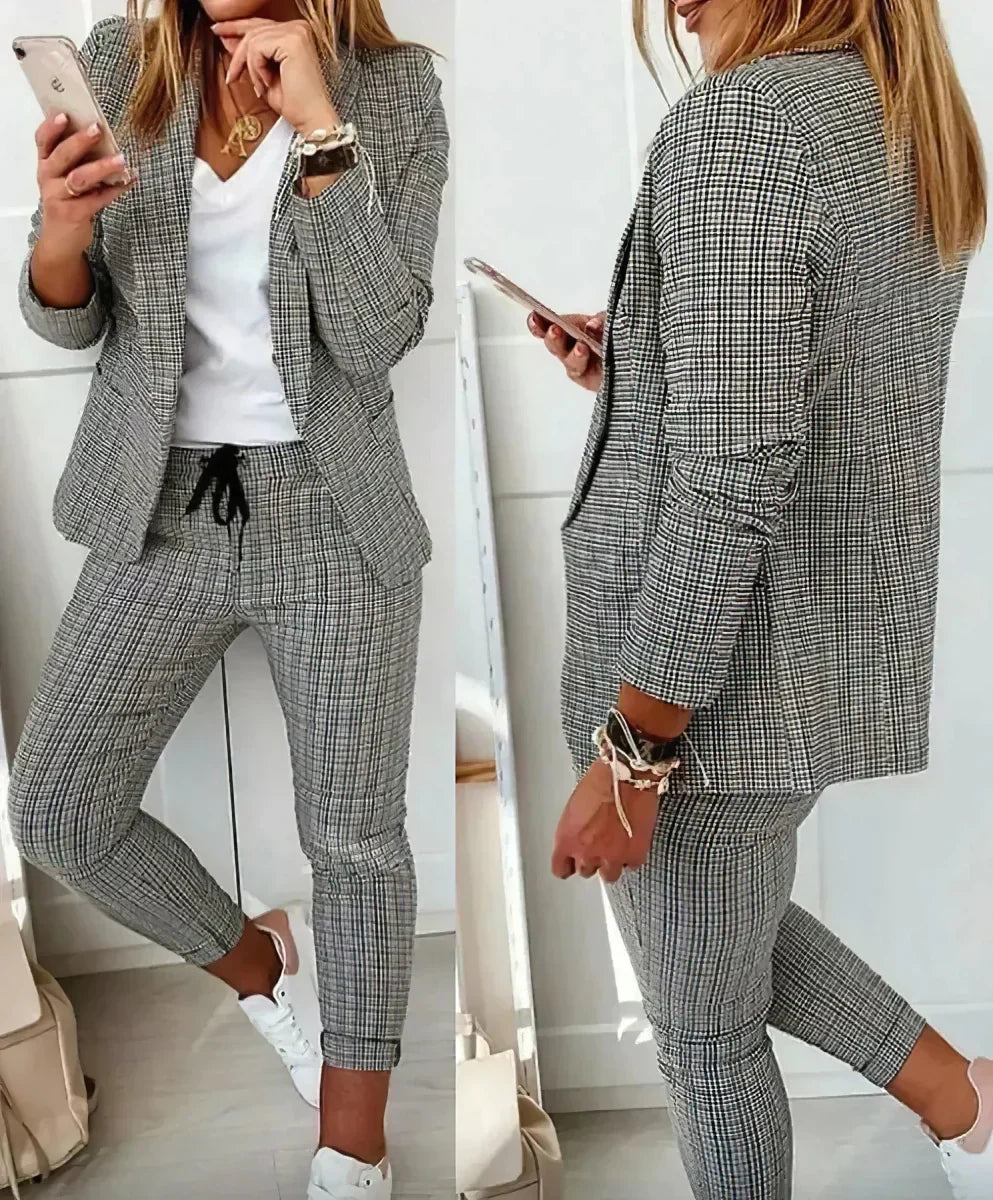Gray elegant women's two-piece business suit. Sophisticated jacket & trousers set for formal professional wear.