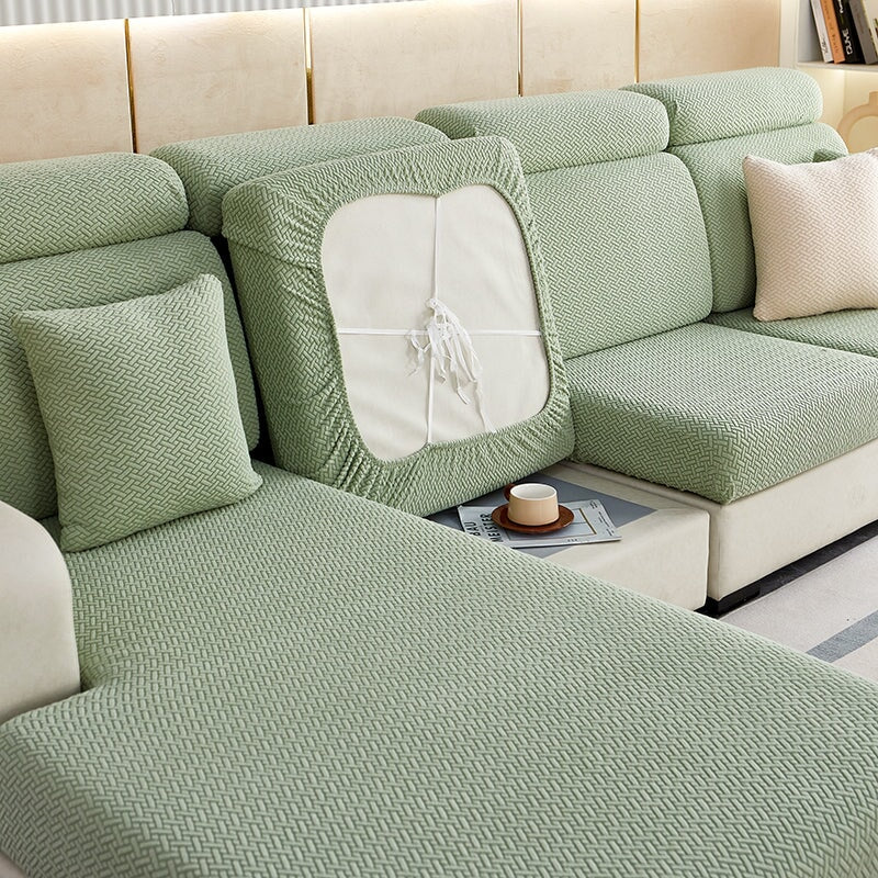 Stretchable sectional sofa cover in vibrant tangerine, snug fit, durable fabric, ideal for home decor and furniture protectio