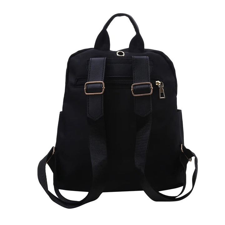 Close-up of a women's black PU leather backpack, showcasing its smooth texture & durable material.