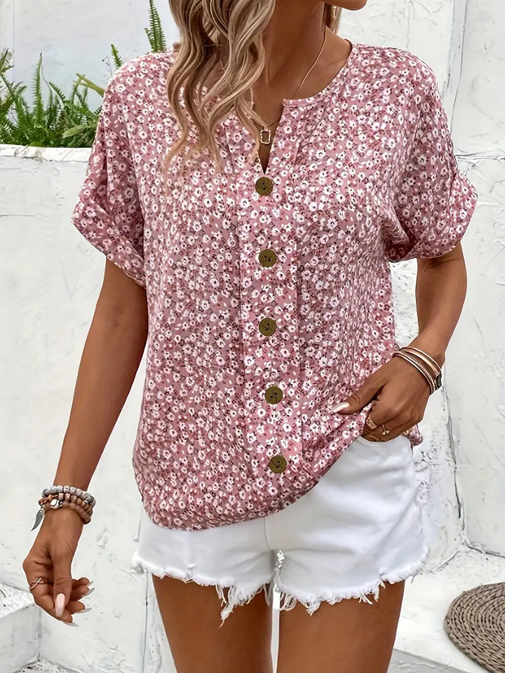 Close-up of elegant women's floral blouse featuring delicate button-front detail and vibrant summer print.