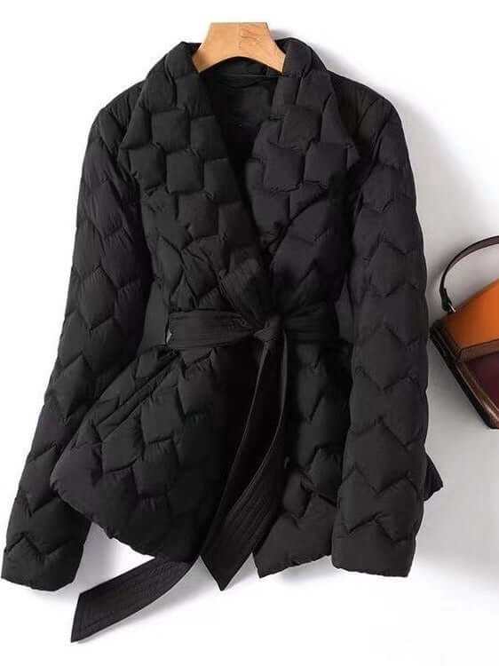 Warm black quilted puffer jacket for women with stylish tie belt. Elegant winter coat for cold weather outerwear.