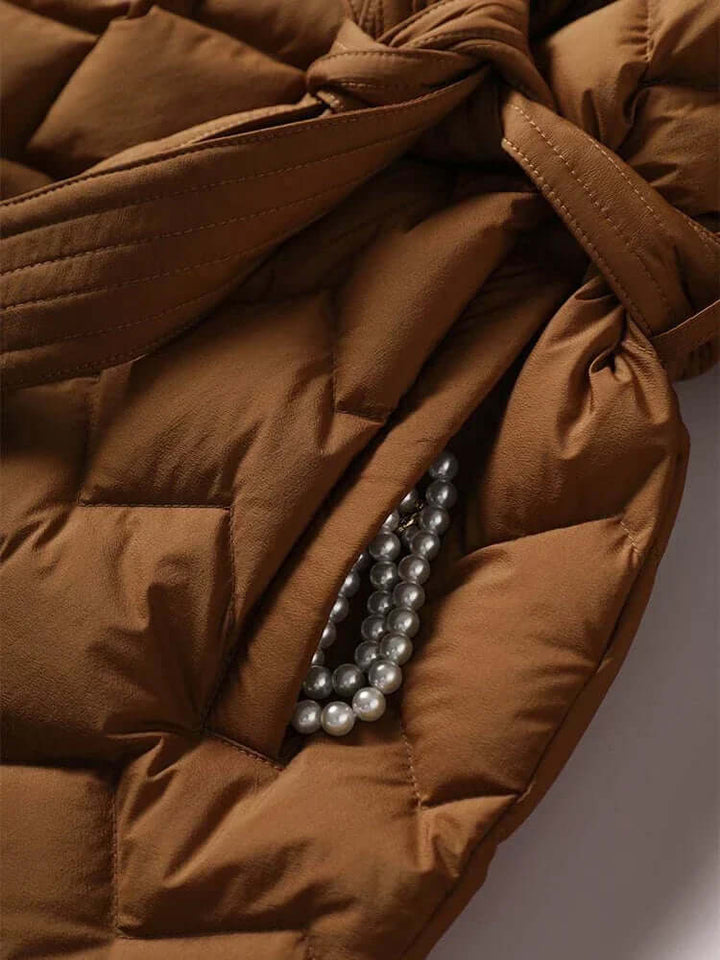 Chic women's quilted winter jacket with tie belt. Stylish outerwear, great for elegant women's fashion in cold weather.
