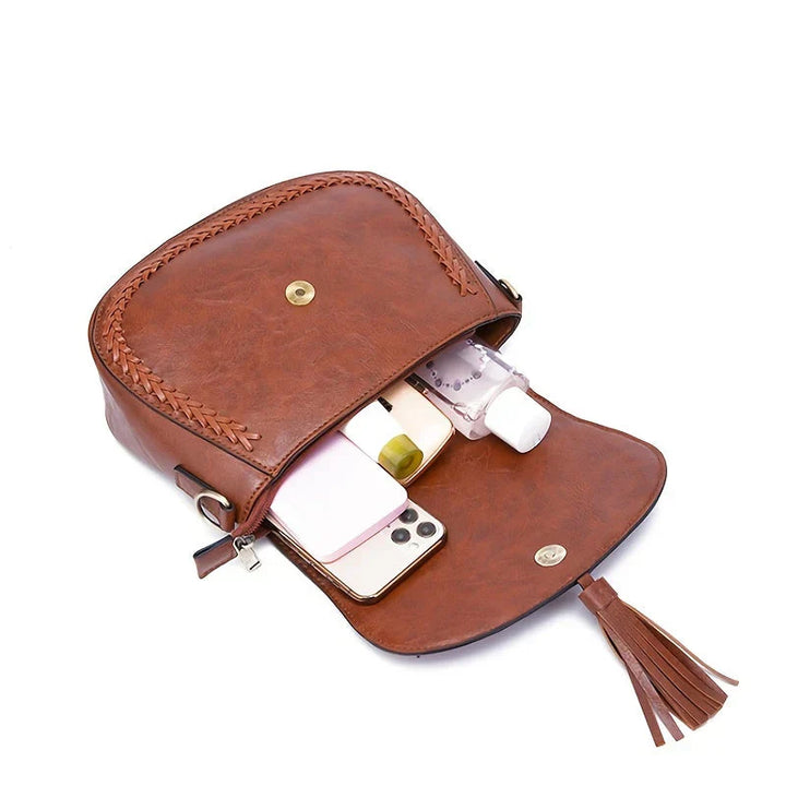 Everyday fashion accessory: women's small shoulder bag, faux leather with a stylish tassel, a chic handbag.