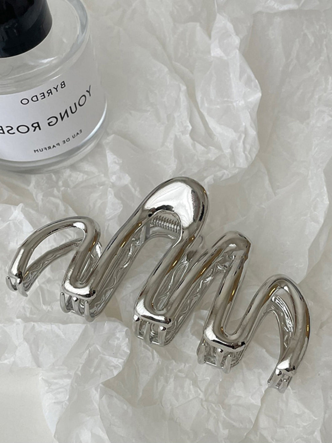 Elegant silver metallic wave hair claw, a stylish women's accessory for secure, sophisticated updos.