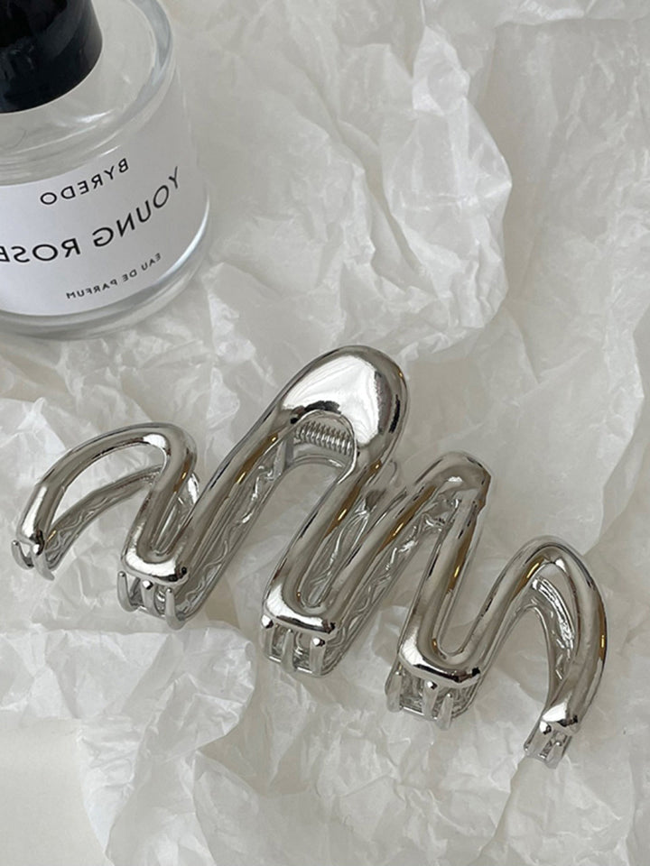Elegant silver metallic wave hair claw, a stylish women's accessory for secure, sophisticated updos.