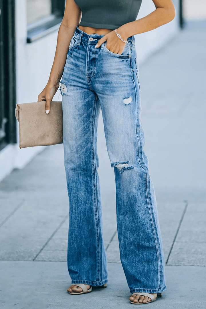 Comfortable women's wide leg blue denim pants with unique tassel accents & ripped details. Casual fashion.