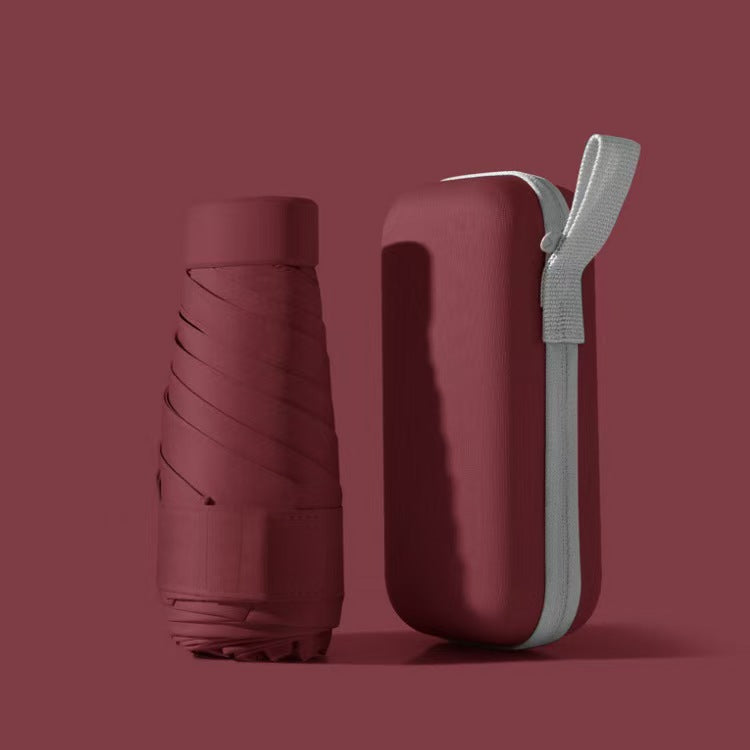 Folded compact travel umbrella in its waterproof protective case, showcasing portability & ready for travel.