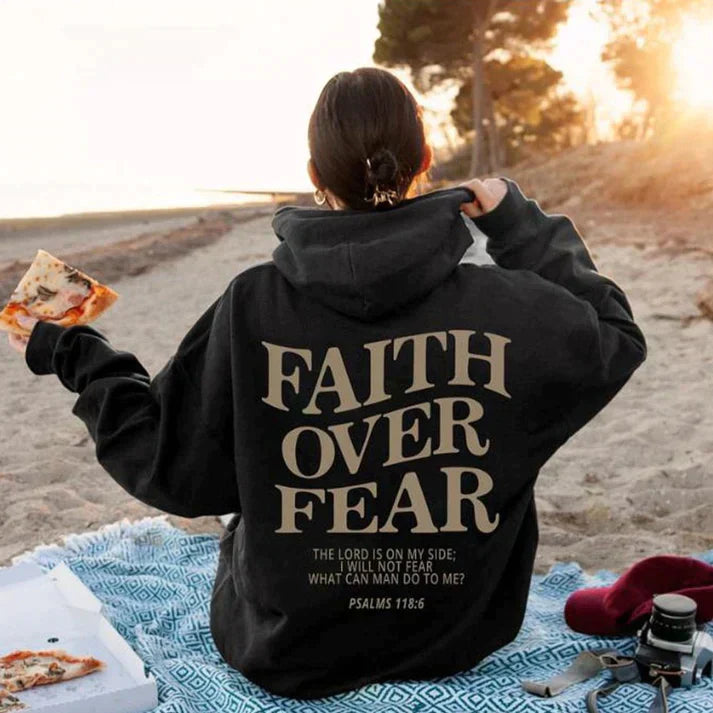 Model wearing an inspirational Unisex Faith Over Fear hoodie with Psalm 118:6, promoting Christian fashion.