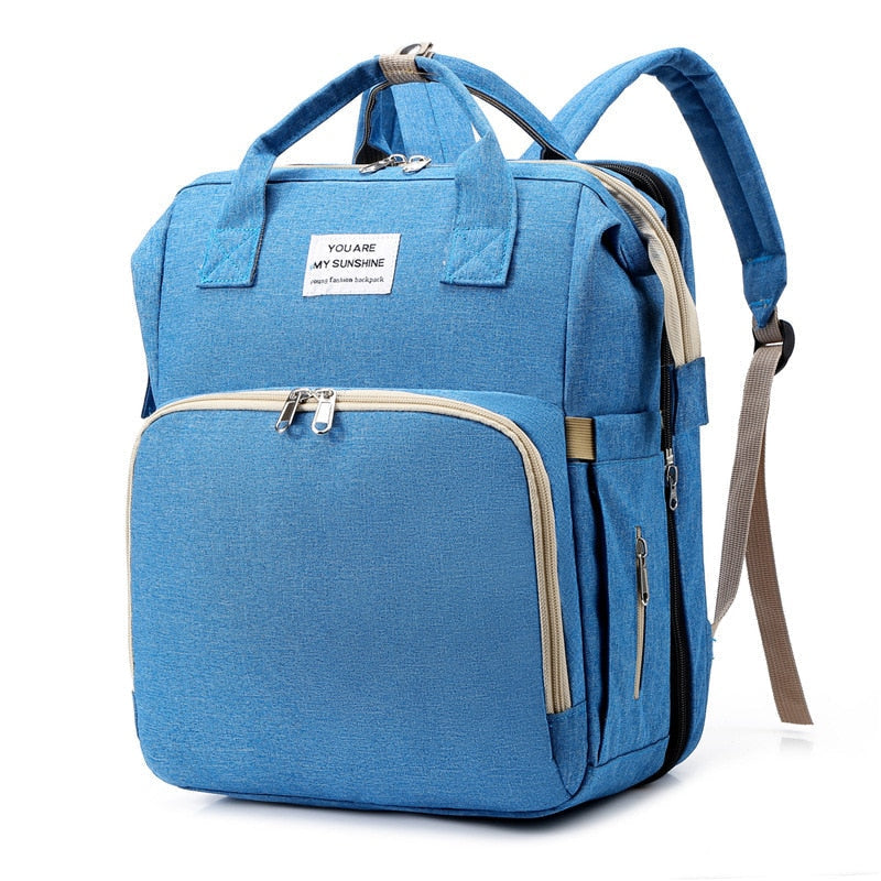 Multifunction baby travel backpack with integrated portable bed and nappy changing station.