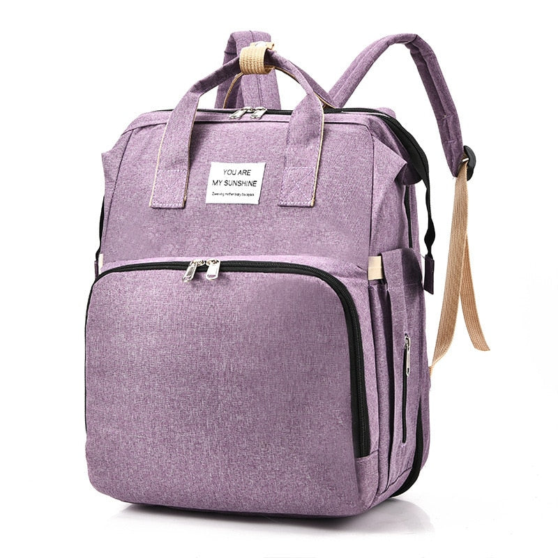 Portable baby bed & nappy bag, a versatile travel backpack and changing station for busy parents.