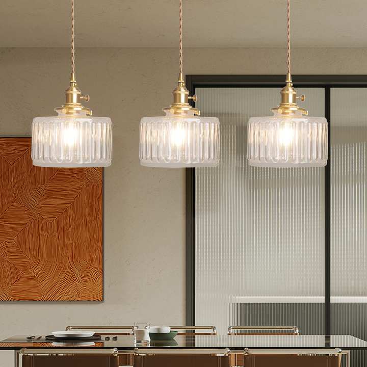 Vintage cylindrical glass pendant lamp casting warm glow; elegant centerpiece for home decor. Perfect for living and dining a