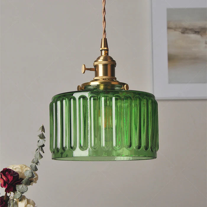 Vintage cylindrical glass pendant lamp casting warm glow; elegant centerpiece for home decor. Perfect for living and dining a