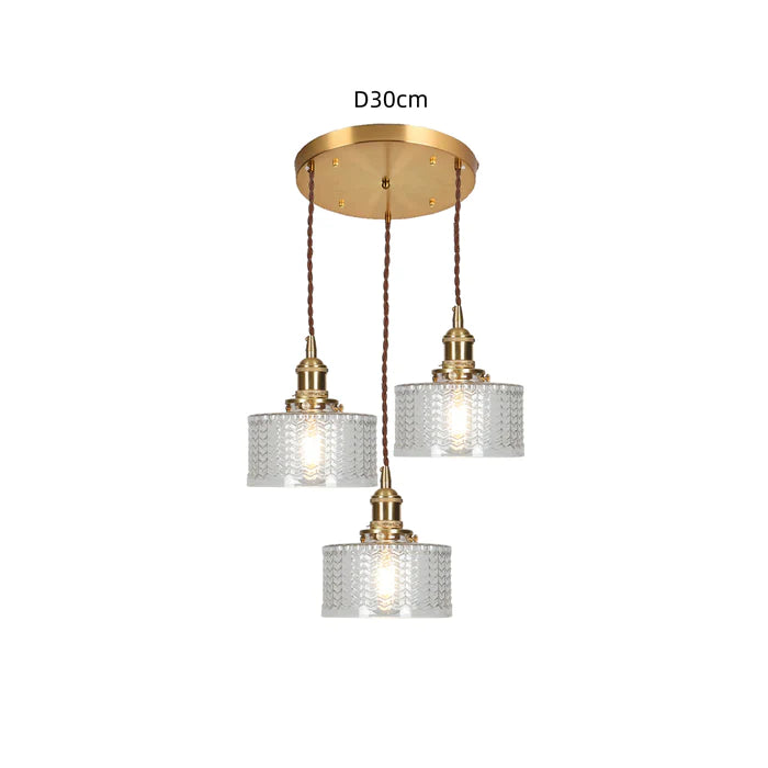 Vintage cylindrical glass pendant lamp casting warm glow; elegant centerpiece for home decor. Perfect for living and dining a