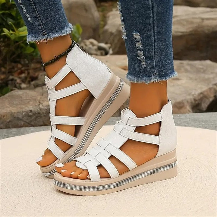 Close-up of white strappy platform sandal showing ankle strap detail and sole