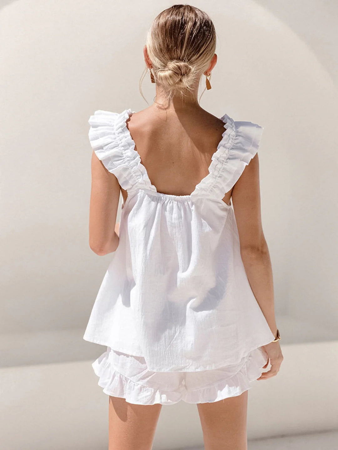 Women's white summer shorts set featuring chic ruffles, perfect casual co-ord for vacation wear.